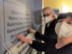 Der Vereinsvorstand beklebt eine Tür in der Musikschule
